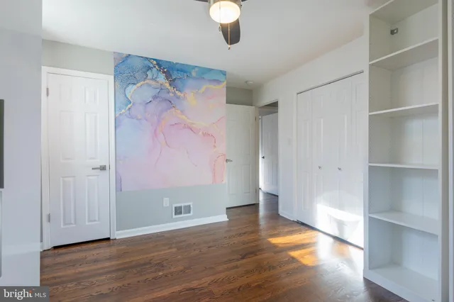 a view of an empty room with wooden floor
