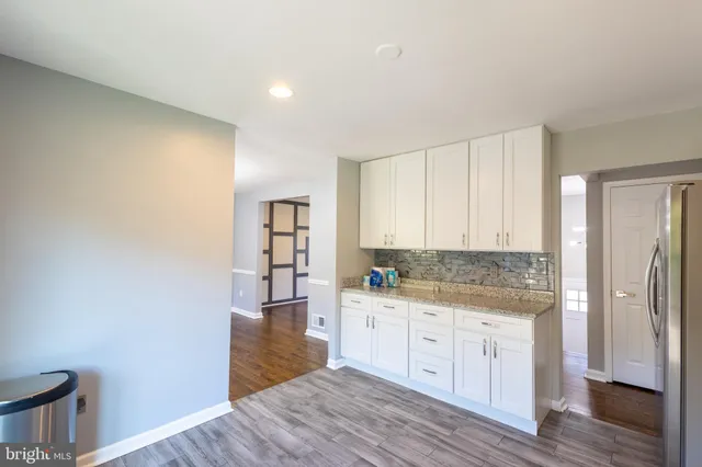 a kitchen with a sink cabinets and wooden floor