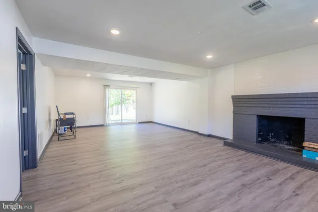 a view of empty room with wooden floor and fireplace