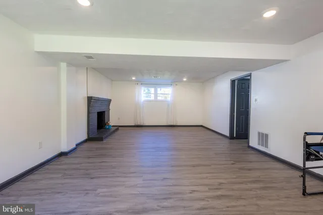 an empty room with wooden floor and fireplace
