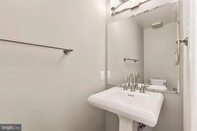 a white sink under a bathroom mirror