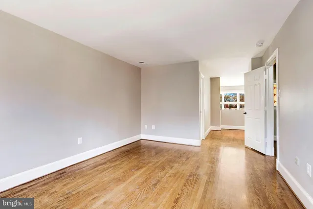 a view of a big room with wooden floor and windows