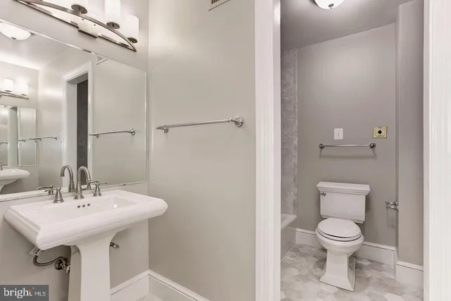 a bathroom with a toilet a sink and a mirror