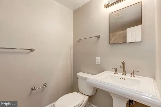 a bathroom with a toilet a sink and mirror