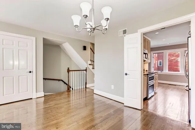 a view of a livingroom with wooden floor and stairs