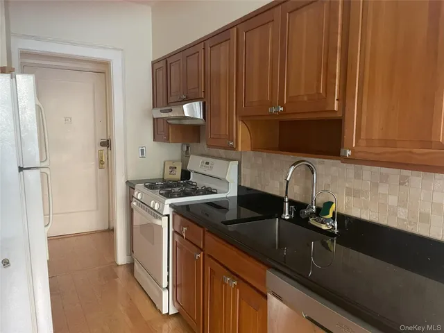 a kitchen with stainless steel appliances granite countertop a sink stove and refrigerator