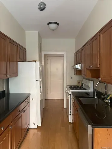 a kitchen with granite countertop a sink stove and refrigerator