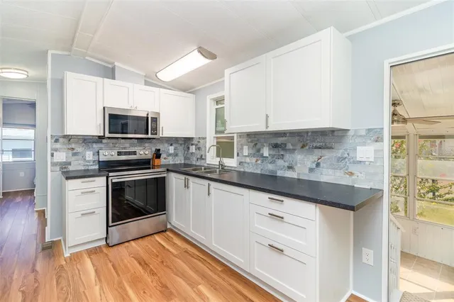 a kitchen with stainless steel appliances a stove sink and microwave