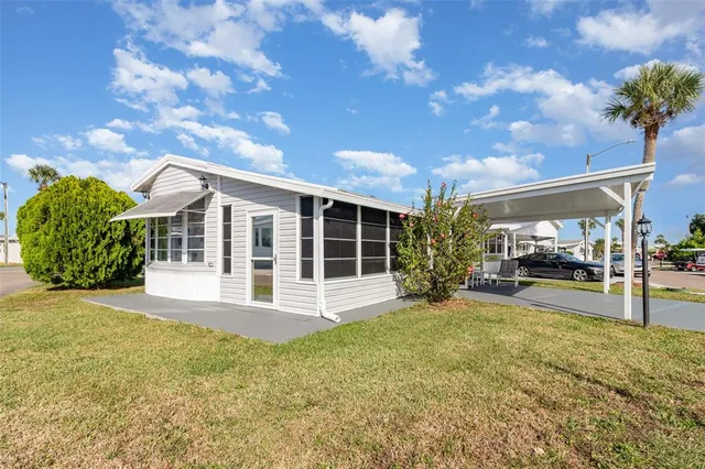 a view of a house with backyard and sitting area