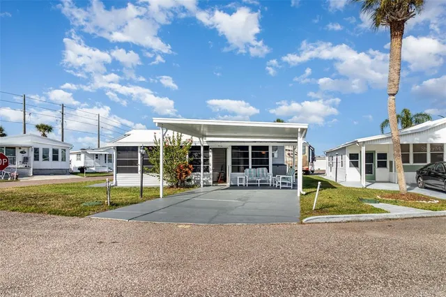 a view of a house with a yard and large tree