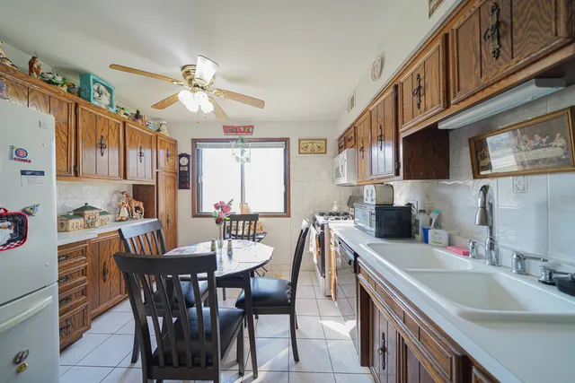 a kitchen with a dining table chairs sink and cabinets