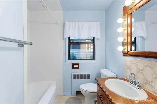 a bathroom with a sink toilet a mirror and bathtub