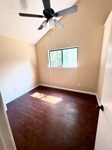 an empty room with a window and ceiling fan