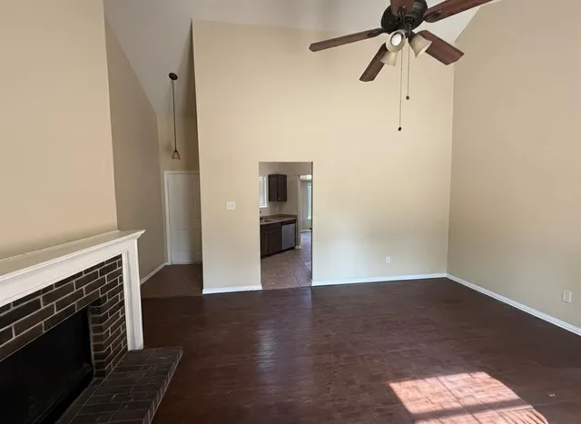 an empty room with wooden floor a ceiling fan and a window