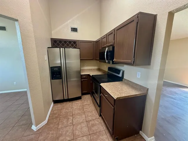 a kitchen with stainless steel appliances granite countertop a refrigerator and a stove