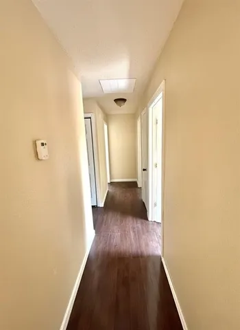 a view of a hallway with wooden floor