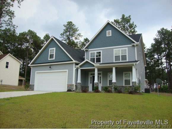 717 Sun Road Aberdeen, NC 28315 - Photo 2 of 14 a front view of a house with a yard and garage