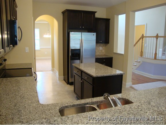 717 Sun Road Aberdeen, NC 28315 - Photo 6 of 14 a kitchen with a sink and a refrigerator