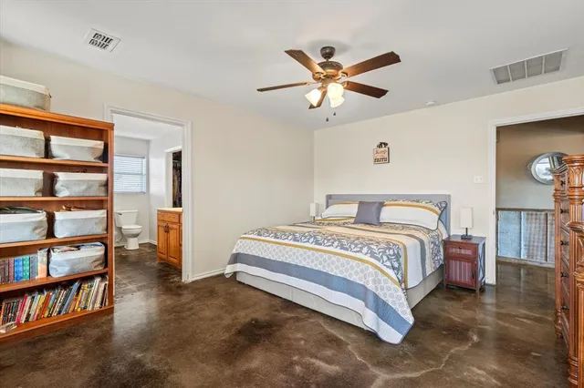 a spacious bedroom with a bed and a chandelier