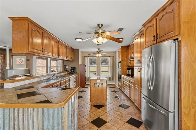 a kitchen with a chandelier appliances and cabinets