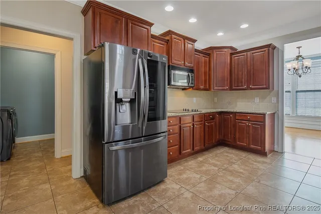 a kitchen with granite countertop a refrigerator and a sink