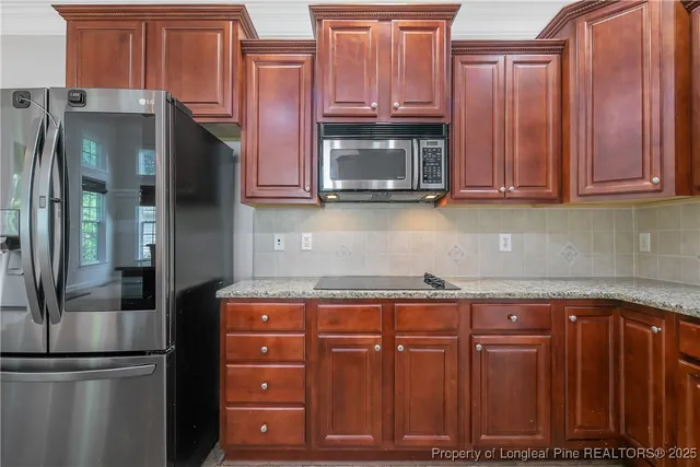 a kitchen with stainless steel appliances granite countertop a refrigerator and a sink