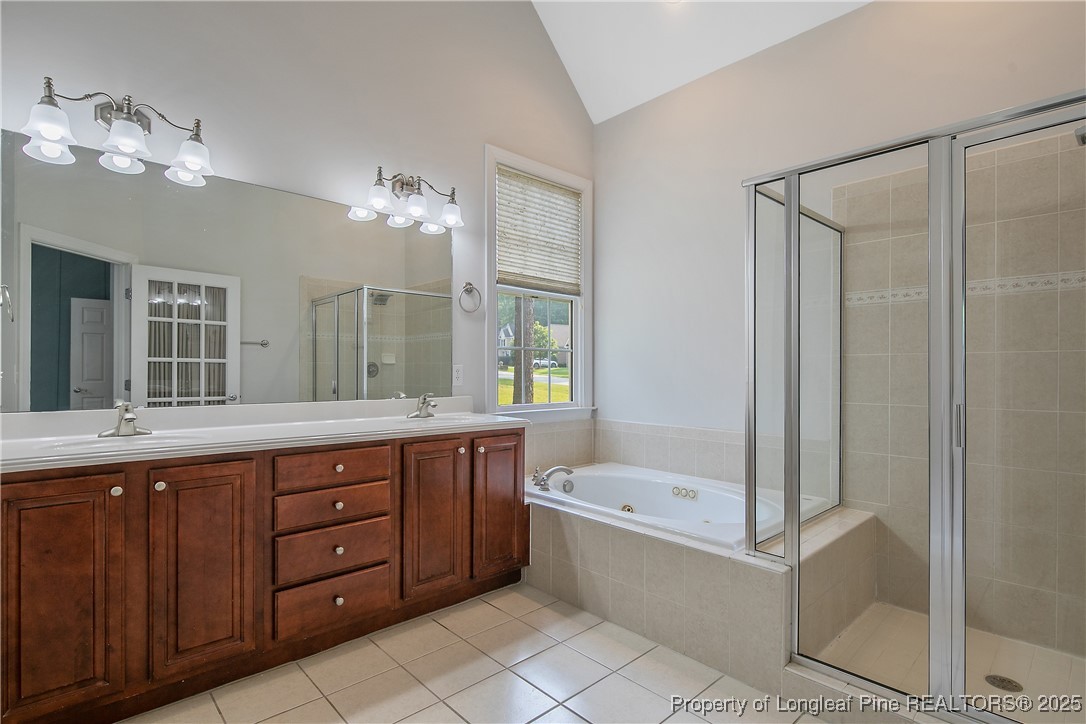 399 Falling Water Road Spring Lake, NC 28390 - Photo 26 of 50 a bathroom with a tub a double vanity sink and mirror