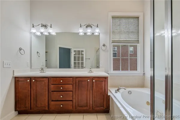 a spacious bathroom with a granite countertop sink a large mirror and a bathtub