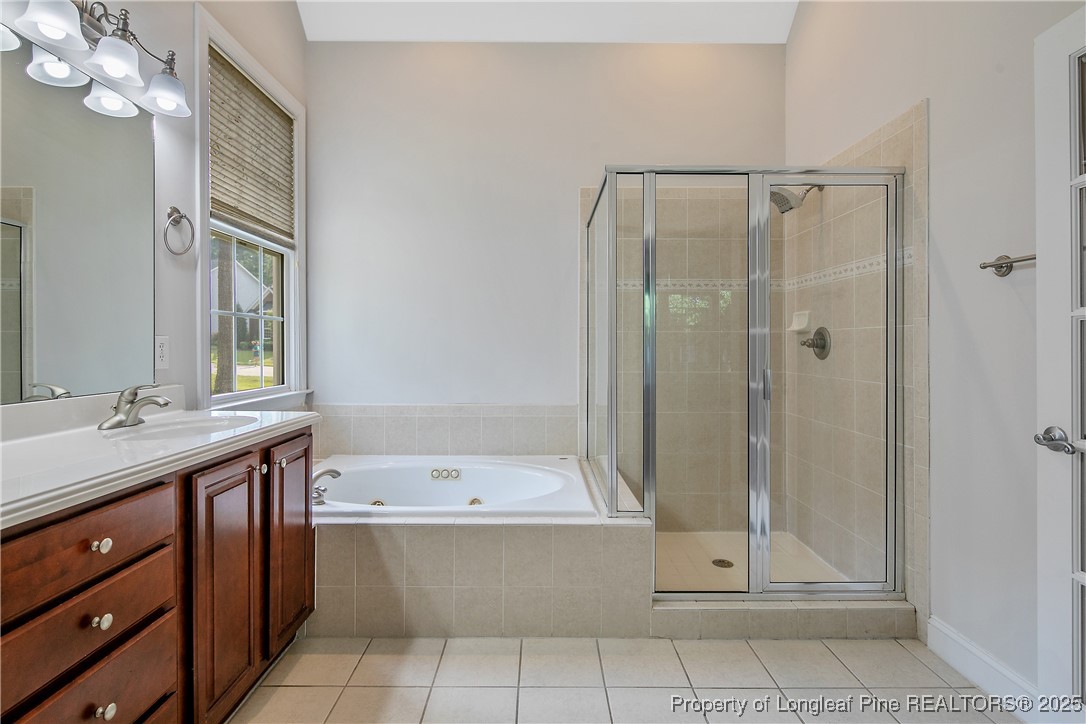 399 Falling Water Road Spring Lake, NC 28390 - Photo 28 of 50 a bathroom with a bathtub a sink and a mirror