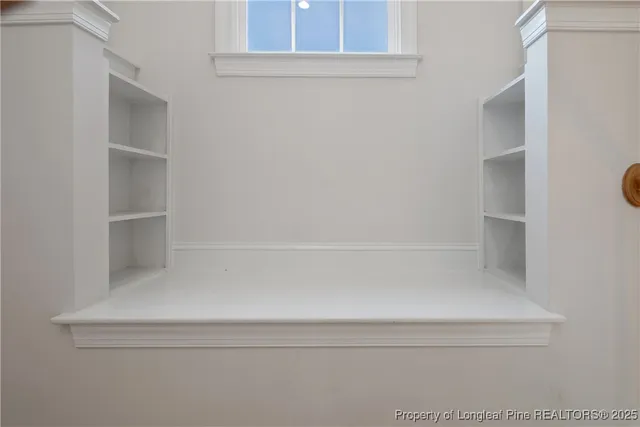 a view of an empty room with window and fireplace