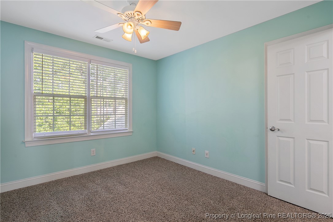 399 Falling Water Road Spring Lake, NC 28390 - Photo 41 of 50 en empty room with windows and chandelier fan