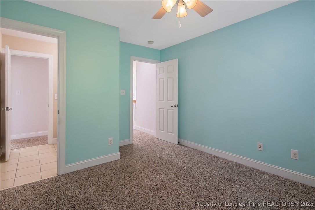 399 Falling Water Road Spring Lake, NC 28390 - Photo 43 of 50 an empty room with a fan and a chandelier fan