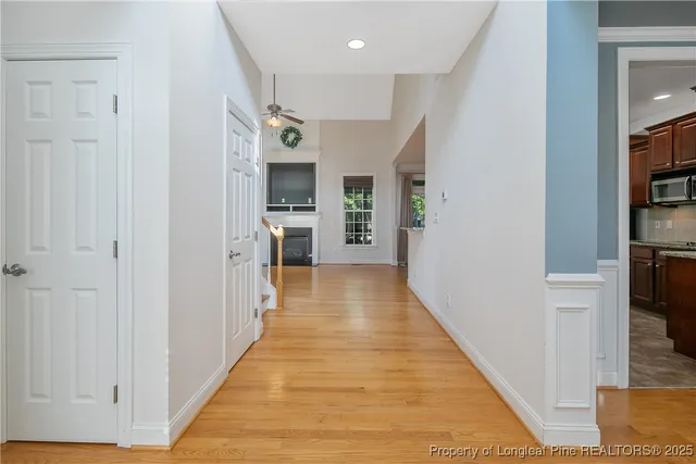 a view of a hallway with wooden floor and staircase