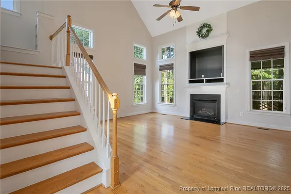 a view of a livingroom with wooden floor a fireplace and a chandelier
