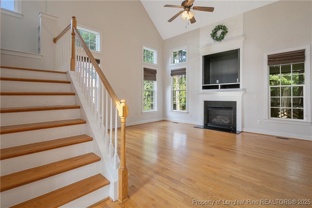 399 Falling Water Road Spring Lake, NC 28390 - Photo 10 of 50 a view of a livingroom with wooden floor a fireplace and a chandelier