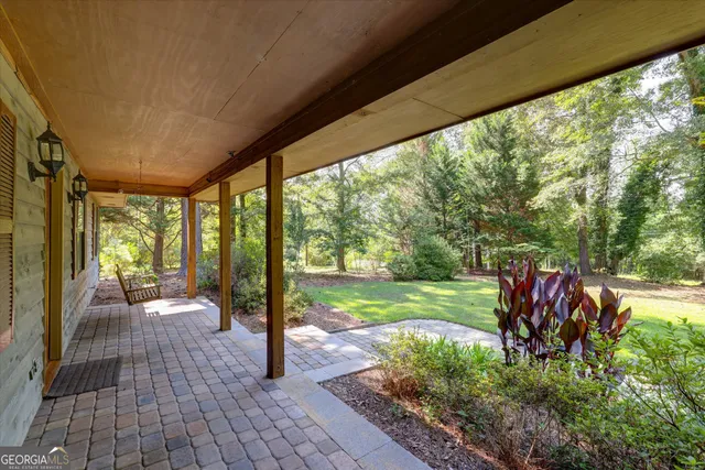 a view of a hallway with wooden floor and a bathroom