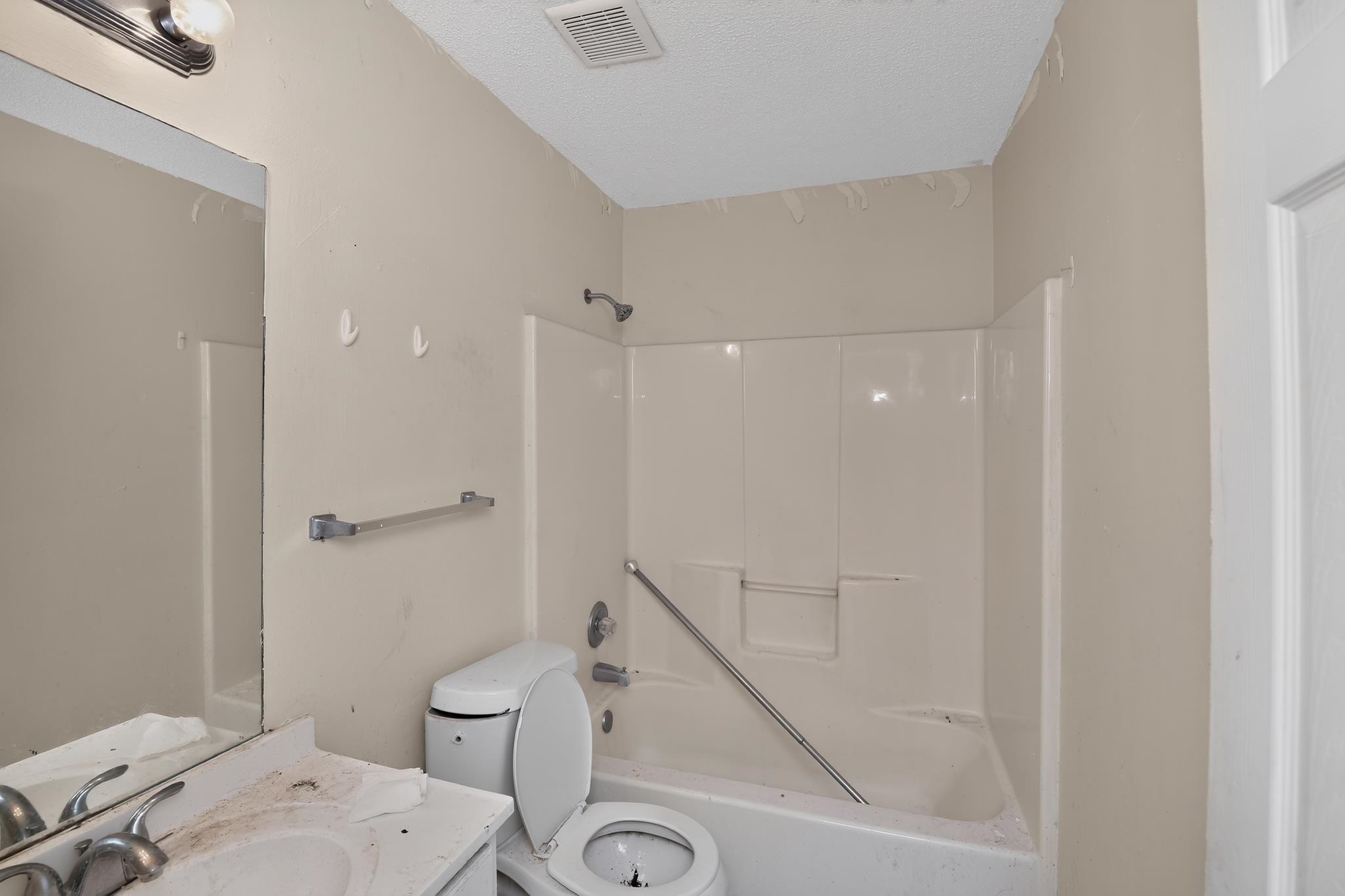 3953 McCain Road Memphis, TN 38109 - Photo 14 of 15 Bathroom featuring a built-in shower/tub combination with a white surround, wall-mounted showerhead, and grab bar
