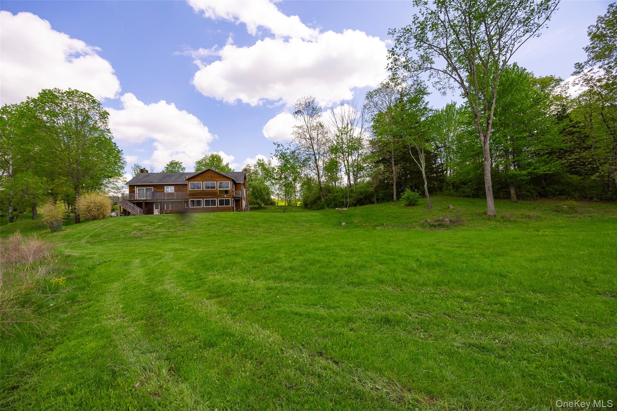 View of grassy yard with a deck
