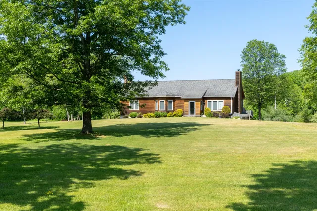 a front view of a house with a yard table and chairs