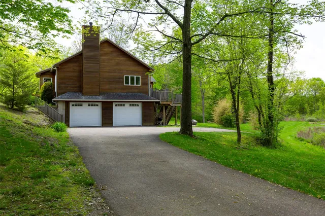 a view of a house with a yard and a large tree