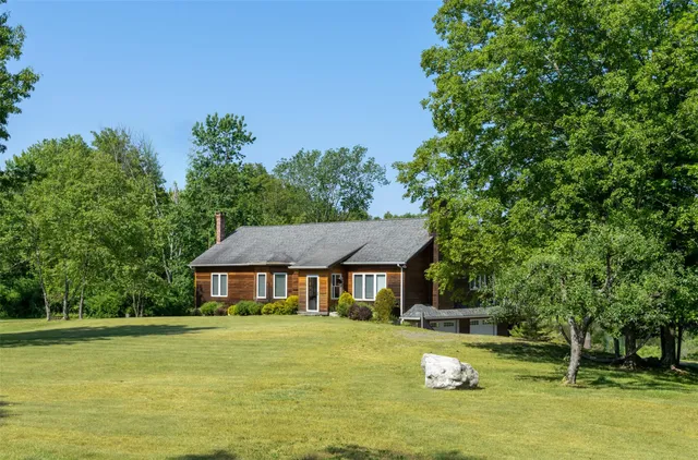 a aerial view of a house with swimming pool next to a big yard