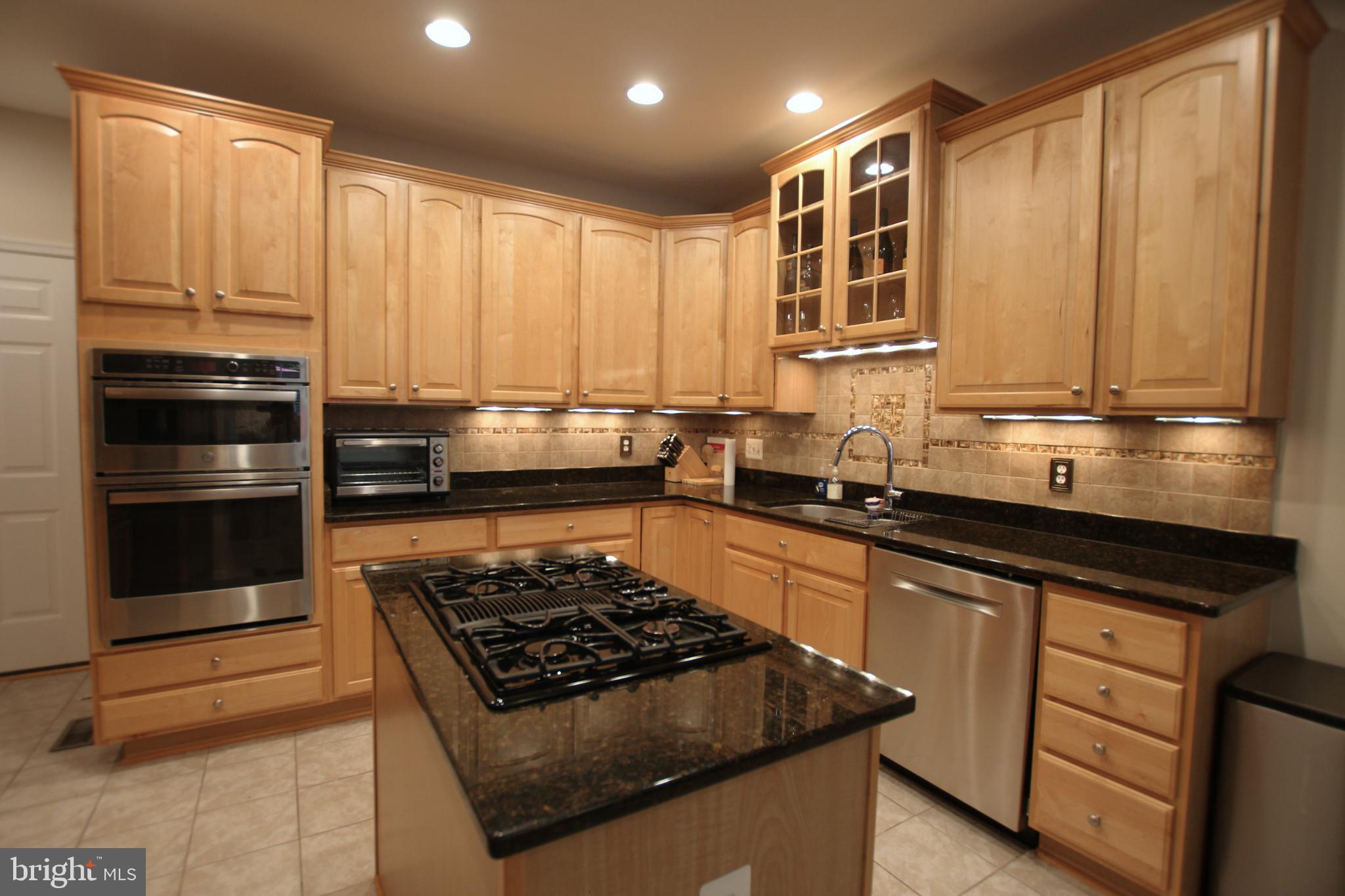 8532 Barrow Furnace Lane Lorton, VA 22079 - Photo 15 of 33 a kitchen with kitchen island granite countertop a stove and a sink