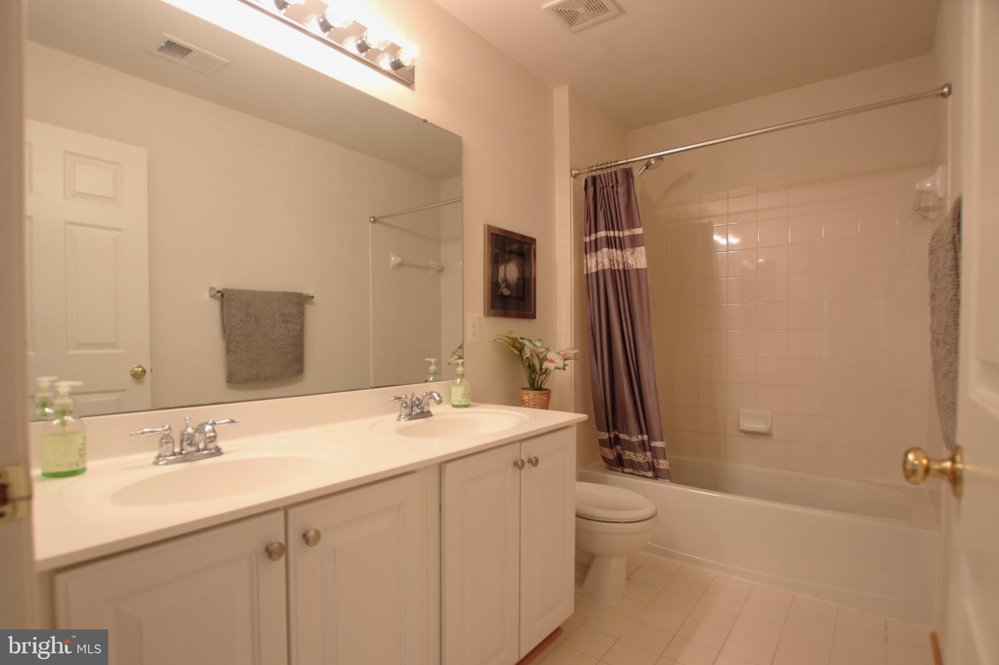 8532 Barrow Furnace Lane Lorton, VA 22079 - Photo 23 of 33 a bathroom with a double vanity sink toilet mirror and shower