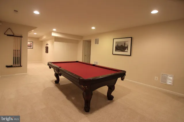 a room with pool table and a bookshelf