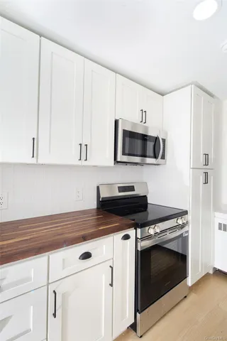 a kitchen with granite countertop white cabinets and stainless steel appliances