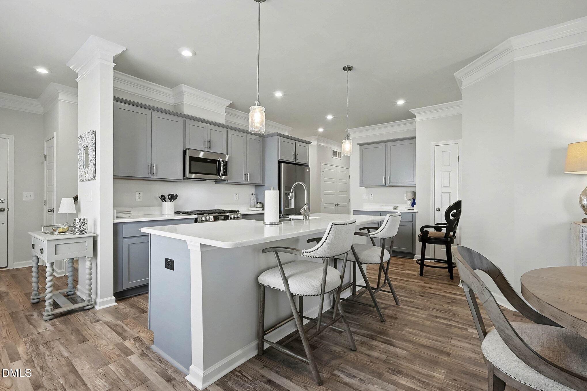 266 Shingle Oak Road Wake Forest, NC 27587 - Photo 8 of 36 a kitchen with kitchen island a white counter space a sink appliances and cabinets
