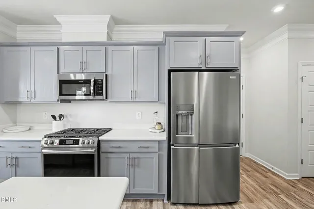 a kitchen with stainless steel appliances a sink a stove and cabinets
