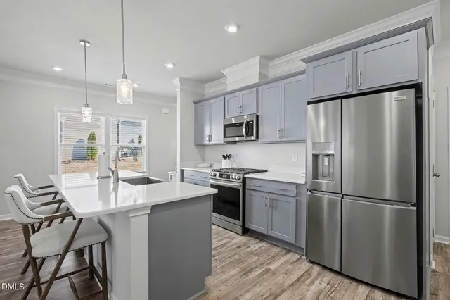a kitchen with a refrigerator sink and cabinets