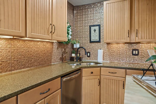 a kitchen with stainless steel appliances granite countertop a sink a stove and cabinets
