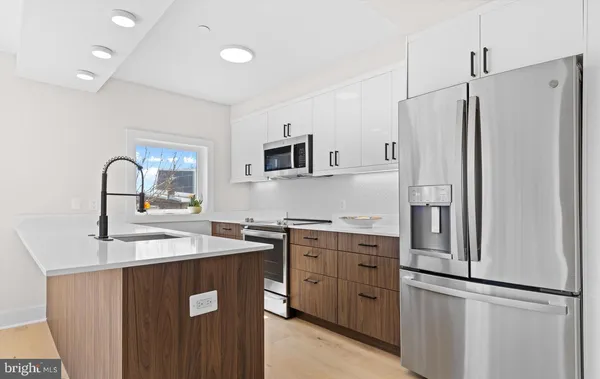 a kitchen with stainless steel appliances a refrigerator sink and cabinets